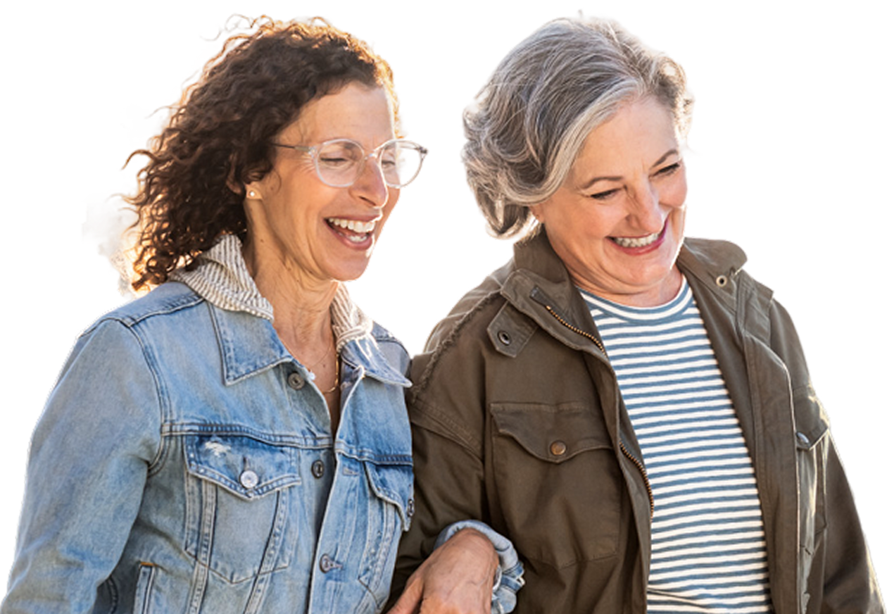 Two women laughing together while walking outside