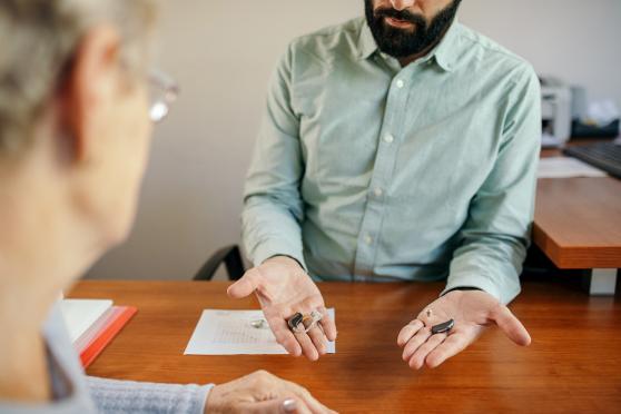 Man presenting hearing aid options to a patient