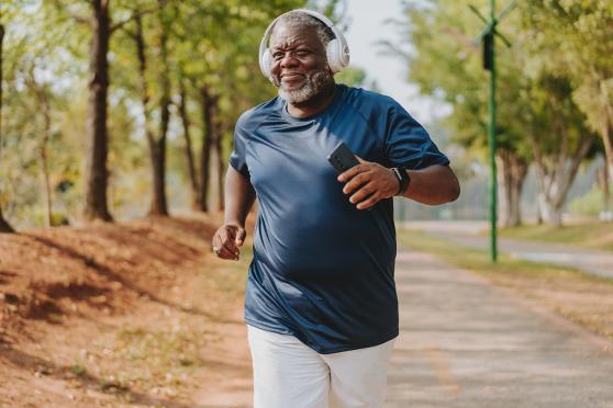 A man running outside with headphones over his ears