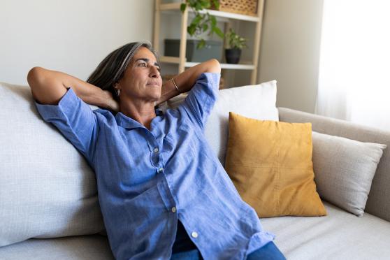 A woman leaned back, sitting on a couch
